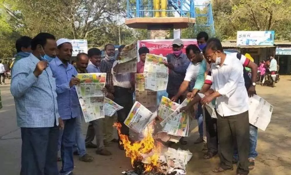 PRC Sadhana Samiti leaders burning the copies of a vernacular newspaper for publishing adverse news items against employees, in front of Ambedkar statue in Atmakur on Thursday