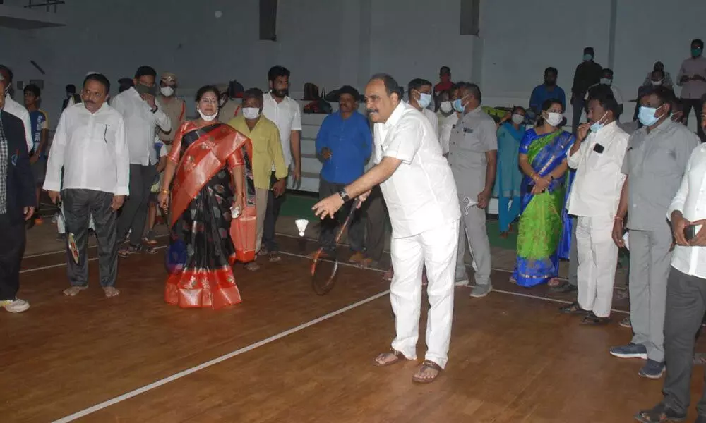 Minister Balineni Srinivasa Reddy playing badminton after inaugurating a two-day tourney in Ongole on Monday.  Mayor Sujatha is  also seen.