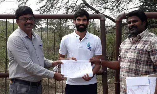 SETVEN CEO Dr Muralikrishna and Renigunta deputy Tahsildar Prem handing over land papers to Kidambi Srikanth on Saturday
