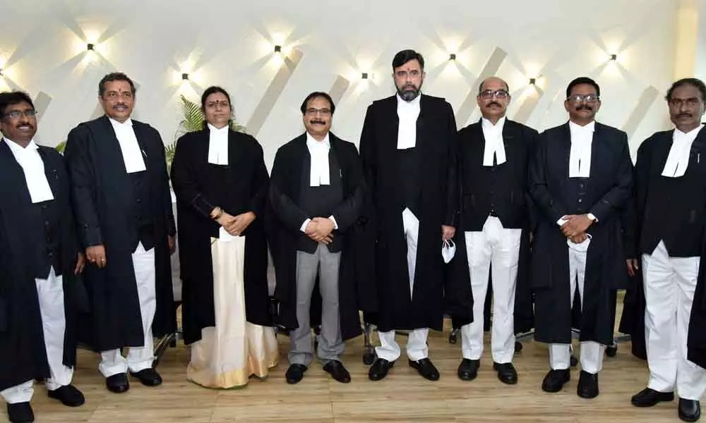 Chief Justice of AP High Court Justice Prashant Kumar Mishra (fourth from left) with the newly-sworn in judges at the High Court at Nelapadu on Monday