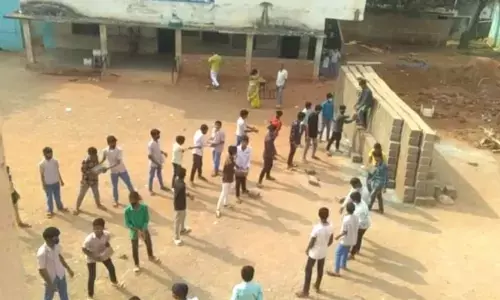 Students carry bricks for construction of school