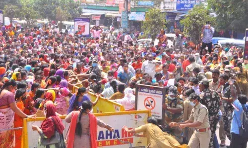 Anganwadi workers and helpers trying to break through barricades to enter the Collectorate in Ongole on Monday