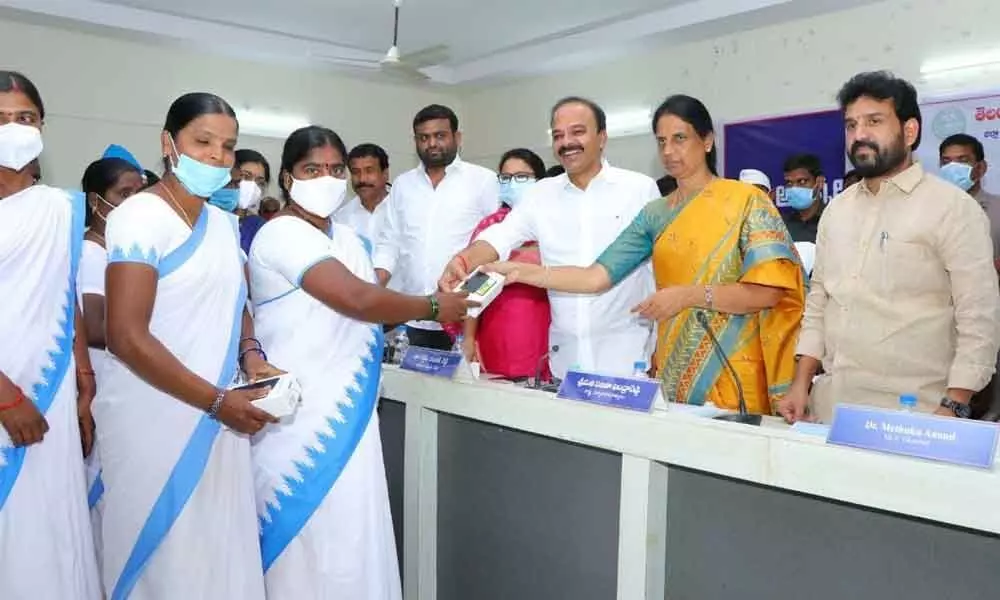 MP Ranjith Reddy along with Education Minister Sabitha Indra Reddy and MLA Methuku Anand distributing smartphones to the Asha workers in Vikarabad on Tuesday