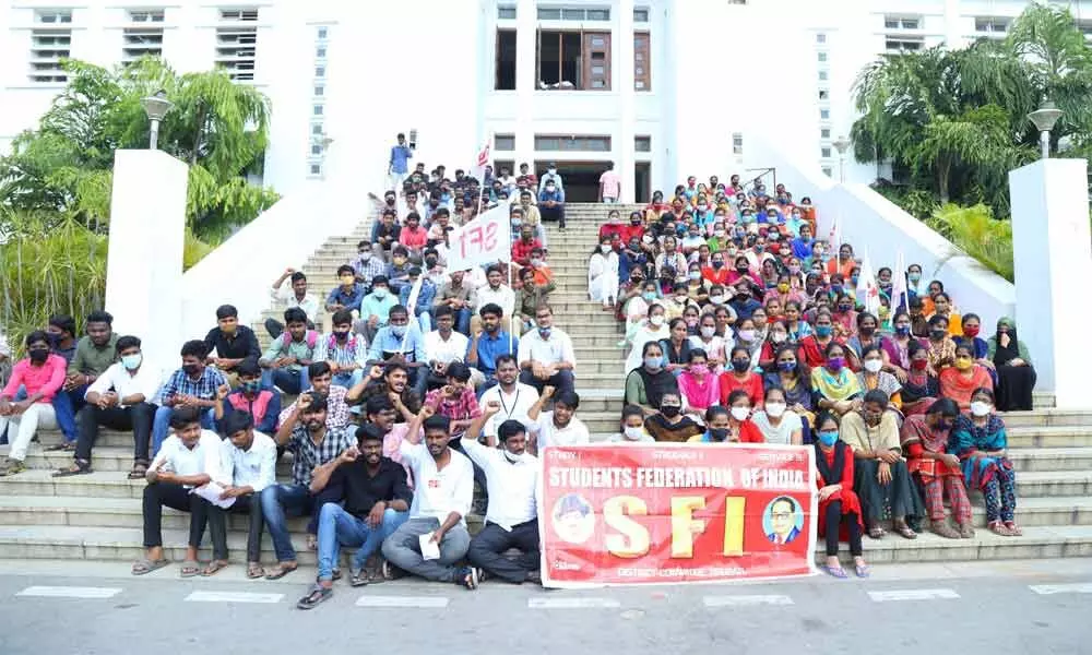 SFI leaders staging a protest in front of SV University administrative building in Tirupati on Wednesday opposing the cut in fellowships