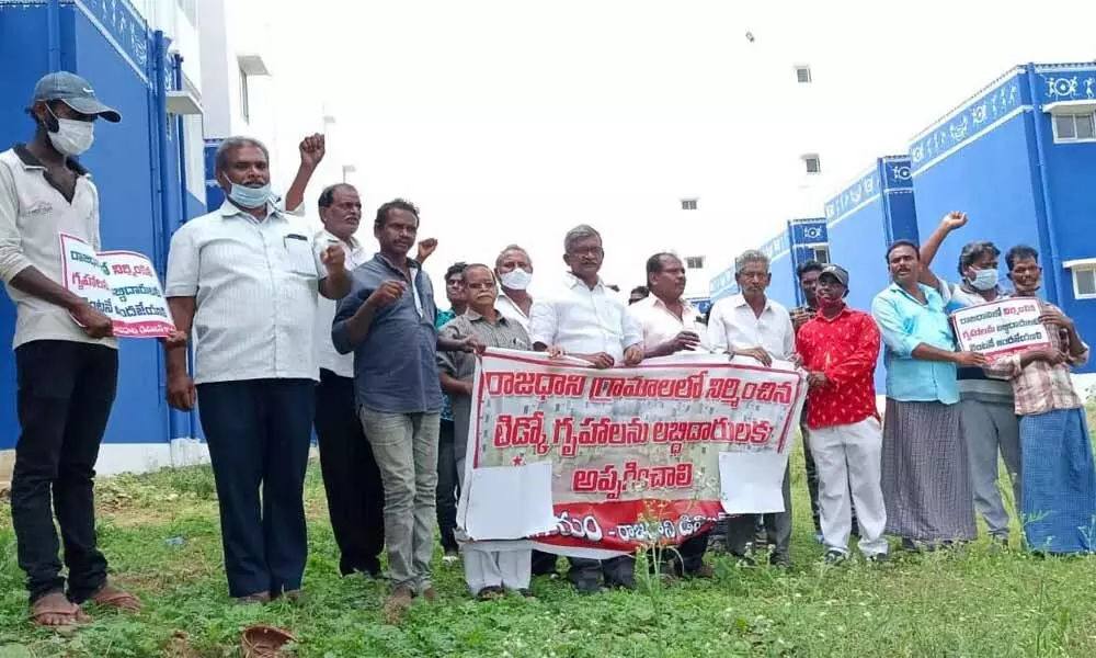 APUCF members headed by its convener Ch Babu Rao staging a protest before the TIDCO houses at Tallayapalem on Wednesday