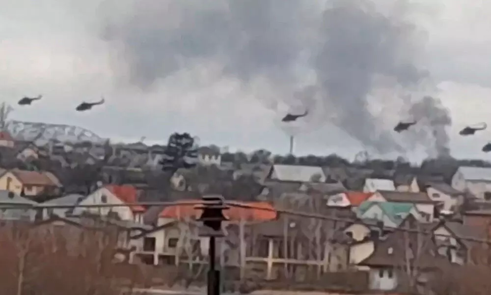 Military helicopters, apparently Russian, fly over the outskirts of Kyiv, the capital of Ukraine, on Thursday
