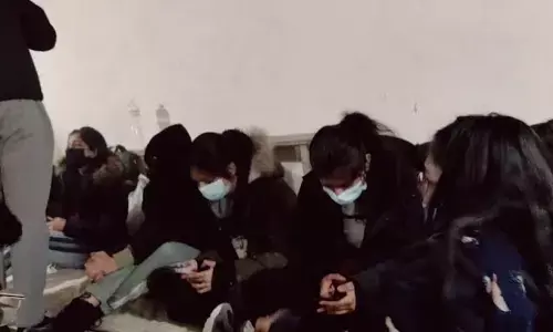 Tensed up students check the status on their mobile phones for a transport facility to reach the Ukraine border