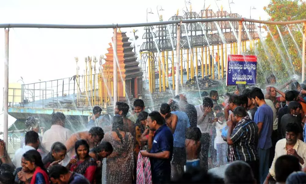 Devotees taking holy bath at Durga ghat near Krishna River in Vijayawada on Tuesday