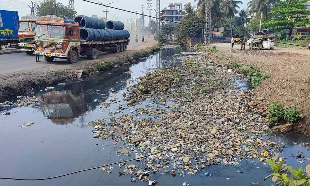 An open drain filled with plastic and other waste