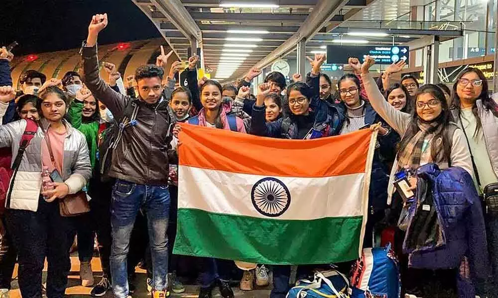 Indian nationals hold the tricolour before boarding a special Air India flight, evacuating Indians from war-torn Ukraine, in Budapest.