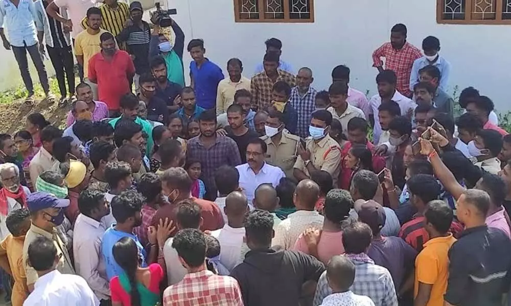 Locals arguing with tahsildar B Prakash at Manthani in Peddapalli district on Wednesday