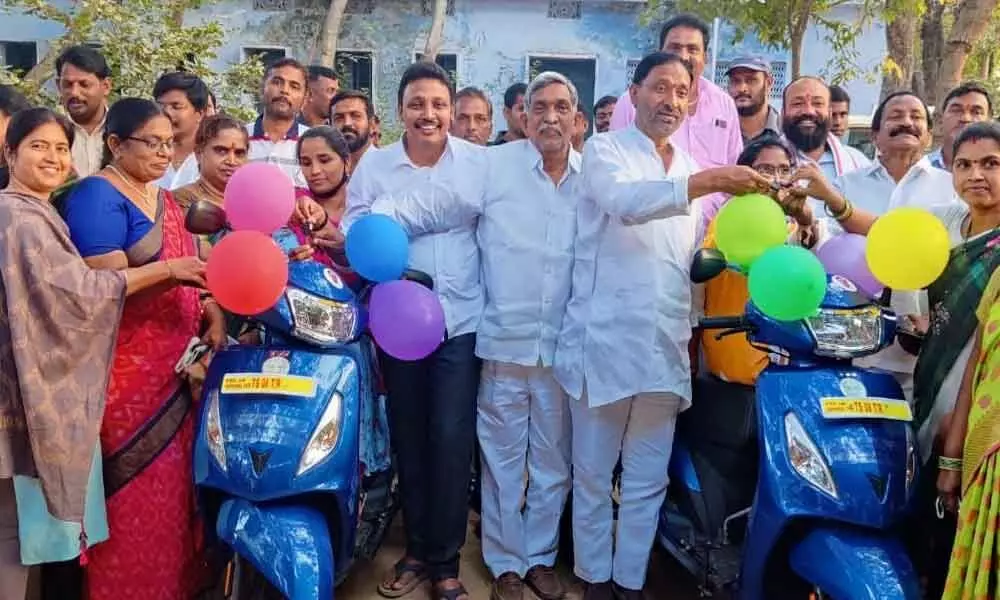 MLA Bhagath and MLC Koti Reddy handing over keys of tri-scooters to beneficiaries in a programme held in Halia on Saturday