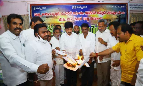 TDP leader and former minister Kollu Ravindra, Kakinada former MLA V Venkateswara Rao along with leaders of fishermen associations burn the copies of GO No 217 at a round-table in Tirupait on Saturday