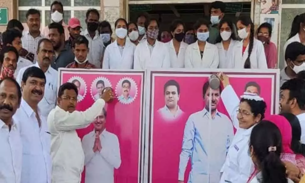 The TRS leaders and hospital staff performing Palabhishekam to portrait of KCR and conveyed special thanks allotment of Medical college in the district on Monday.