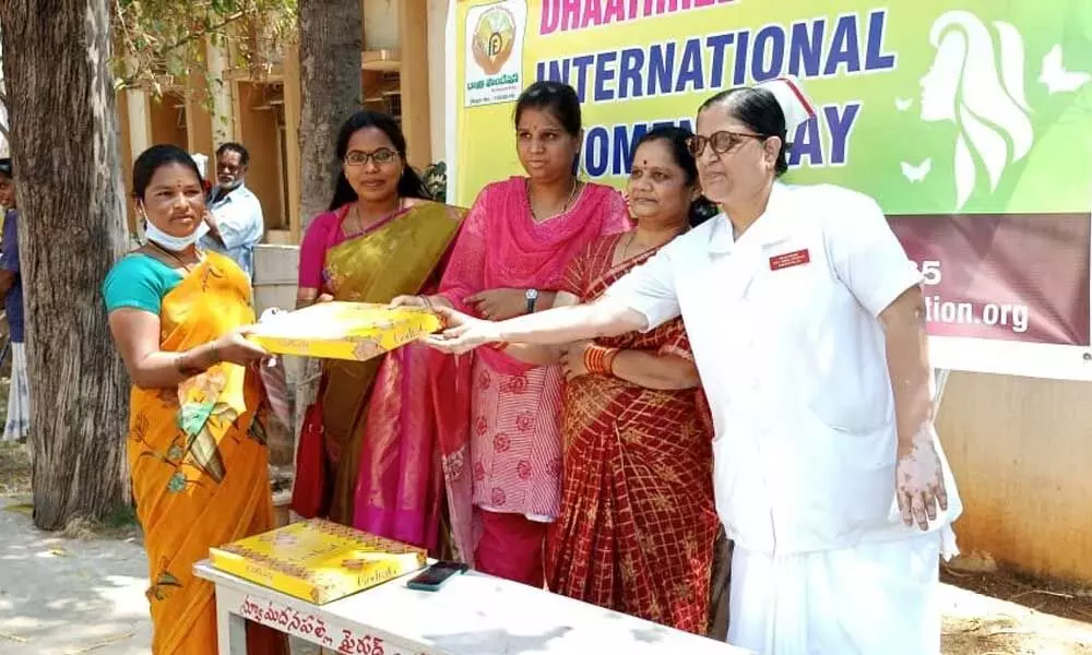 Dhatri Foundation members distributing saris to women workers at the Government Hospital in Madanapalle on Tuesday