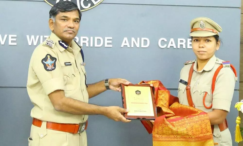 Director General of Police KV Rajendranath Reddy presenting merit award to a woman police personnel at a programme at the State police office in Vijayawada on Tuesday