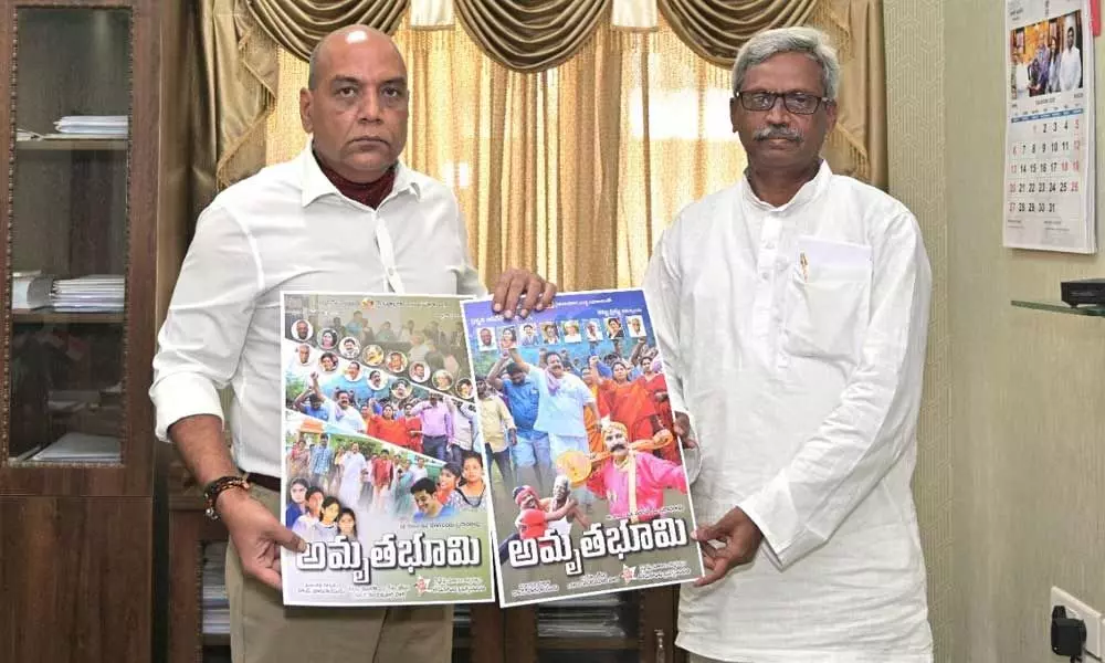 Special Chief Secretary to Governor RP Sisodia (left) releasing a poster of Telugu feature film ‘Amrita Bhoomi’ at Raj Bhavan in Vijayawada  on Wednesday