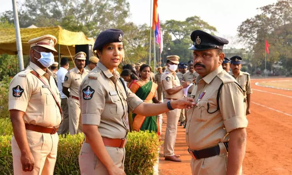 Prakasam SP Malika Garg presenting Utkrisht Seva Medal to head constable Kalluri Narasimha Rao at a programme at Parade Grounds in Ongole on Friday
