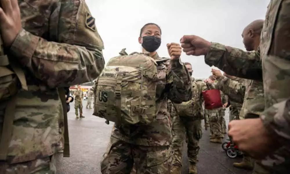 A line of soldiers with the U.S. Armys 87th Division Sustainment Support Battalion, 3rd Division Sustainment Brigade (left) get a fist bump from members of the command staff during their deployment to Europe on Friday
