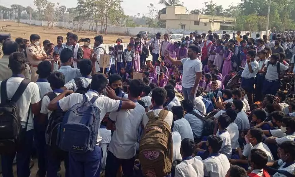Students staging a dharna at Govt Model School at Bhogapuram in Vizianagaram district on Monday