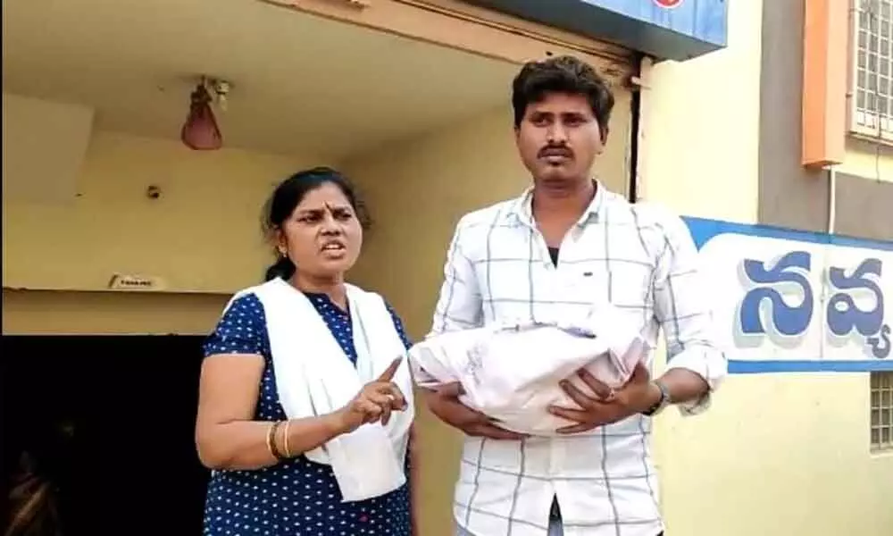 Charan Kumar, the husband of Yamuna, with the body of baby in front of Navya hospital in Dhone.