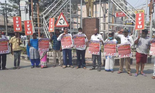 IFTU leaders releasing poster of nationwide strike at Ambedkar statue near RTC bus stand in Tirupati on Saturday