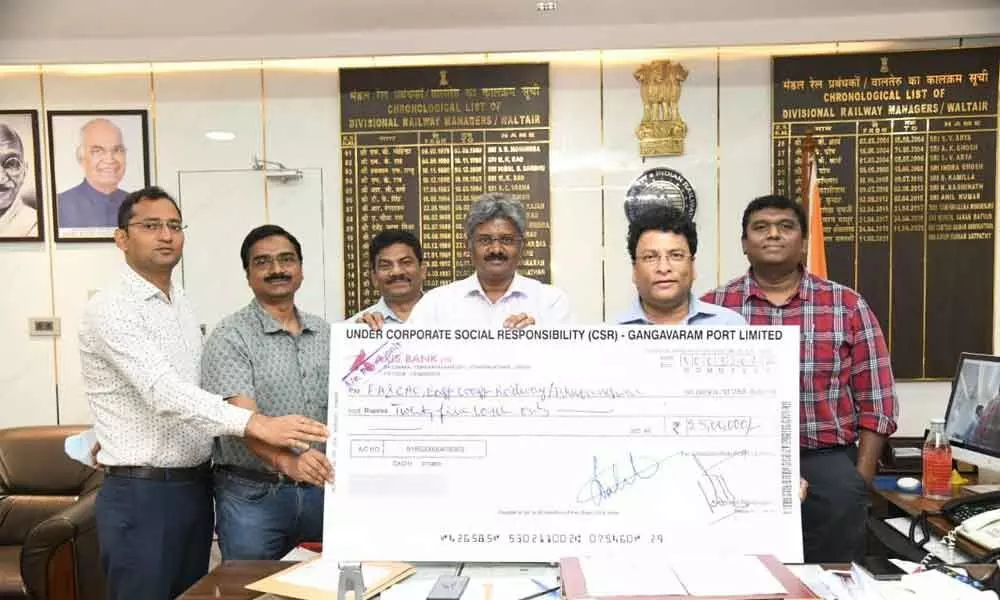 Gangavaram Port Limited CEO N Sambasiva Rao handing over a cheque as a part of CSR activity to DRM Anup Satpathy in Visakhapatnam on Monday