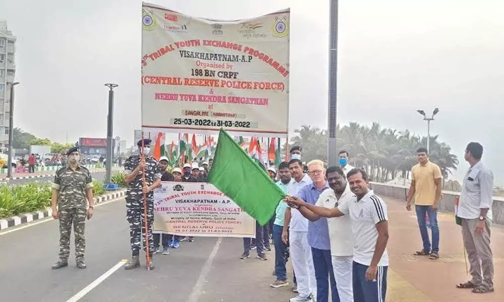 Holding flags and banners, tribal youths stage a demonstration at RK Beach in Visakhapatnam on Tuesday