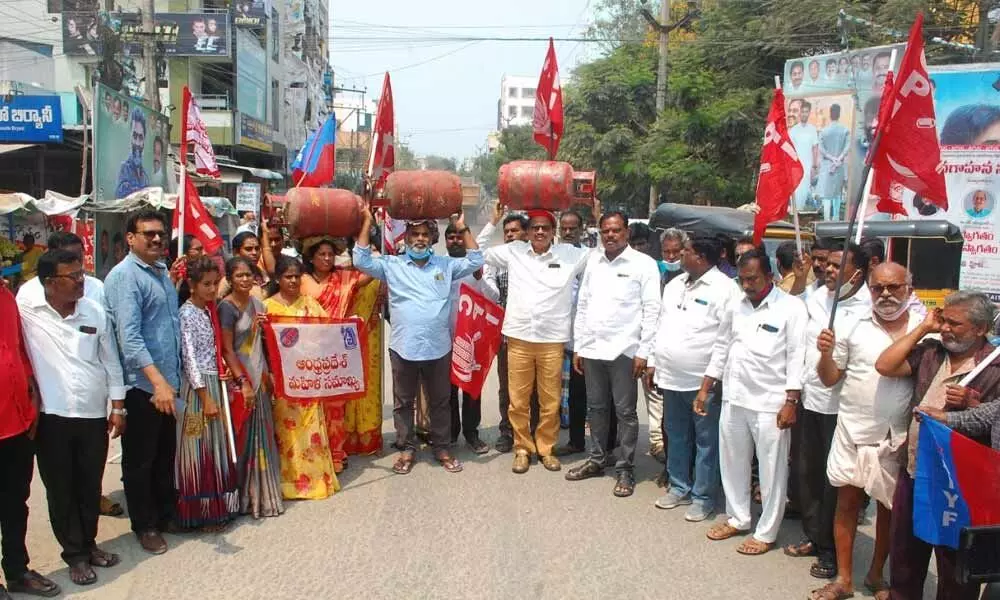CPI leaders protesting against hike in domestic gas cylinders price by carrying cylinders on their heads at Park Circle in Bairagipatteda in Tirupati on Wednesday