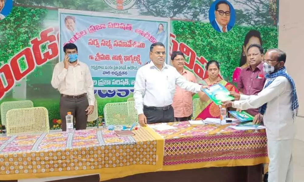 District Collector Vivek Yadav distributing housing documents to the beneficiaries at Tadikonda MPDO office on Thursday