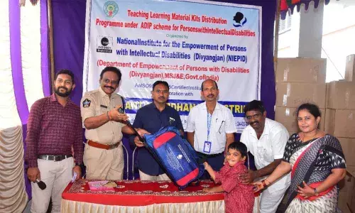 Peddapuram Additional Superintendent of Police A Srinivasa Rao distributing TLM kits to a mentally challenged student at Pulimervu village on Thursday