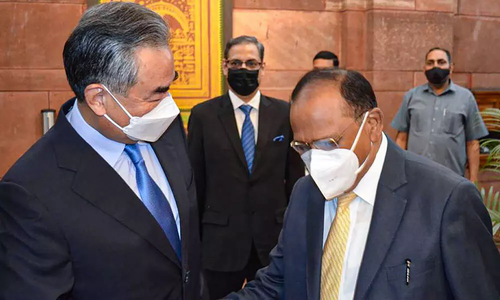 Chinas Foreign Minister Wang Yi shakes hands with National Security Adviser Ajit Doval, during their meeting, at the South Block, in New Delhi on Friday