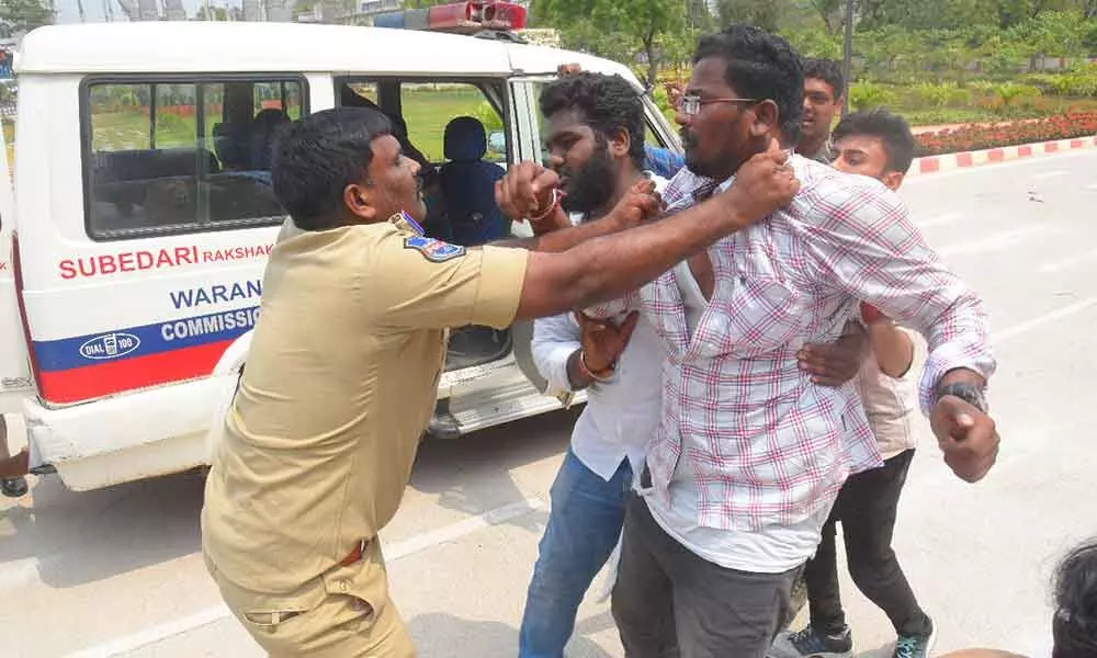 A cop pulling a student by holding his collar at Hanumakonda Collectorate on Saturday