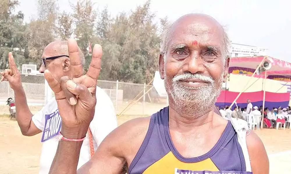 95-year-old Katterashala Komuraiah who won the gold medal in 5 km walking at the 8th Masters Athletics Championship shows victory sign at Jawaharlal Nehru Stadium in Hanumakonda on Saturday