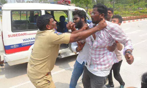 A cop pulling a student by holding his collar at Hanumakonda Collectorate on Saturday
