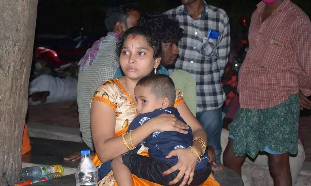 A woman with her child at the Ruia Hospital in Tirupati. Her husband was injured in the private bus mishap and is undergoing treatment at the hospital.