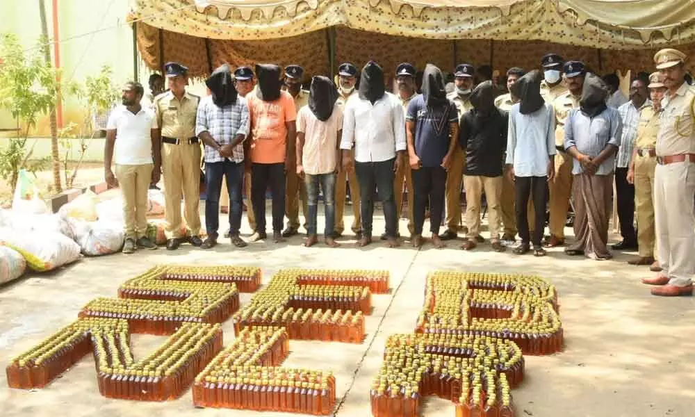 SEB officials produce seized liquor along with the accused before media in Nellore on Tuesday