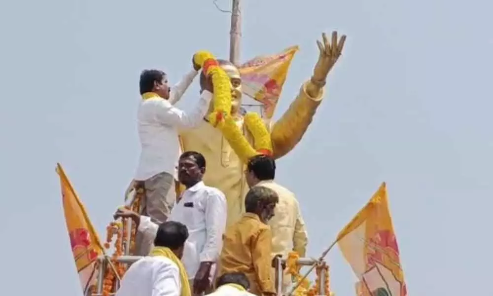 TDP Yerragondapalem in-charge Guduri Erixion Babu removing the garland, placed by Budala Ajitha Rao group, from NTR statue in Yerragondapalem on Tuesday