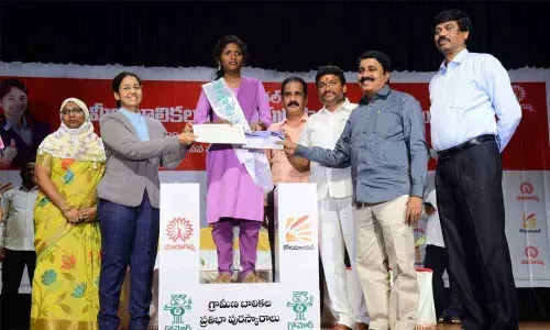 Additional SP KGV Saritha giving scholarship to a girl student at a programme at Makineni Basava Punnaiah Vignana Kendram in Vijayawada on Tuesday