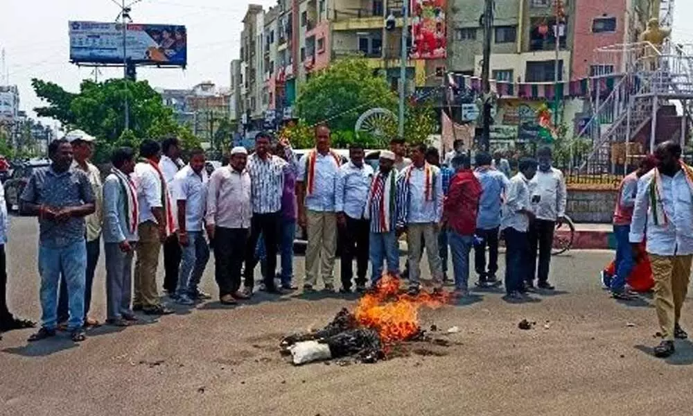 Congress leaders burning effigies of CM KCR and PM Modi in Karimnagar on Monday