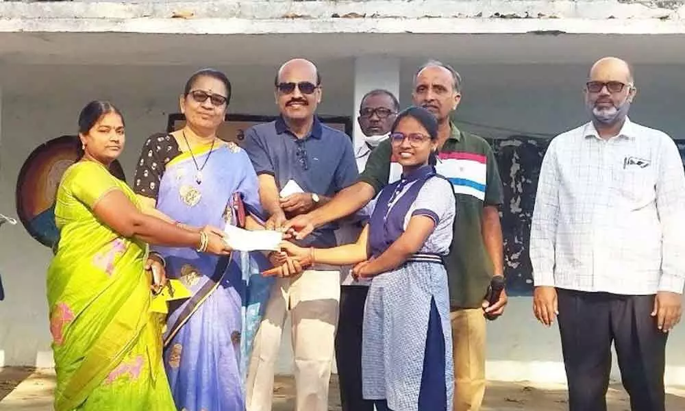 Dr Ramadevi of Siddipet handing over a cheque for Rs 25,000 to a student at  ZPHS Sanigaram in Karimnagar district on Wednesday