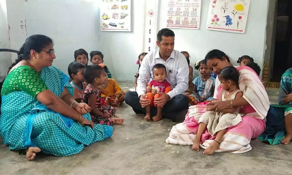 District Collector Himanshu Shukla interacting with the children at an Anganwadi at Kandulapadu village on Friday