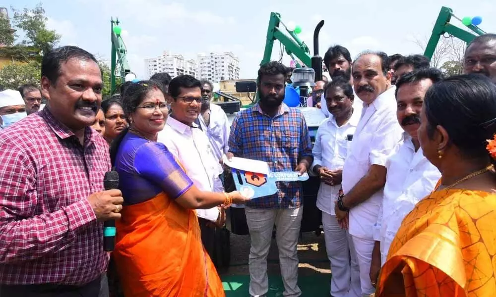 Minister Balineni Srinivasa Reddy and Collector AS Dinesh Kumar distributing drain cleaning machines to the beneficiaries in Ongole on Friday
