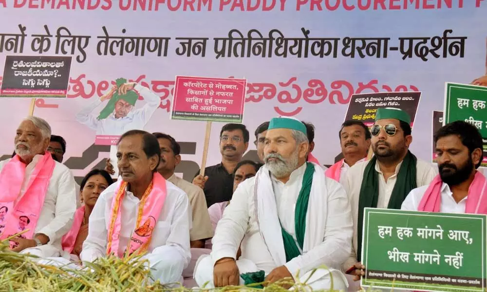 Telangana CM K Chandrashekar Rao along with Bharatiya Kisan Union spokesperson Rakesh Tikait holding a sit-in protest against Centres paddy procurement policy in New Delhi on Monday