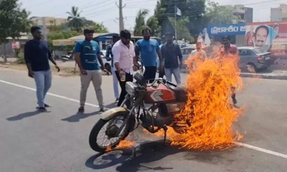 YSRCP activists burning a motorbike in front of the district party office in Ongole on Monday
