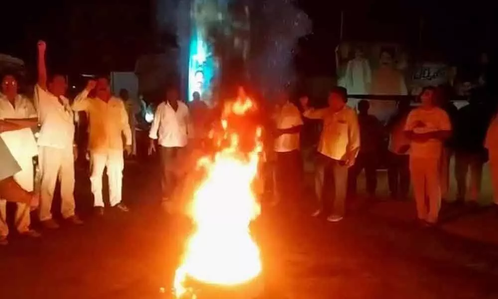 Followers of Chodavaram MLA Karanam Dharmasri burning a tyre as a mark of protest in Anakapalle district