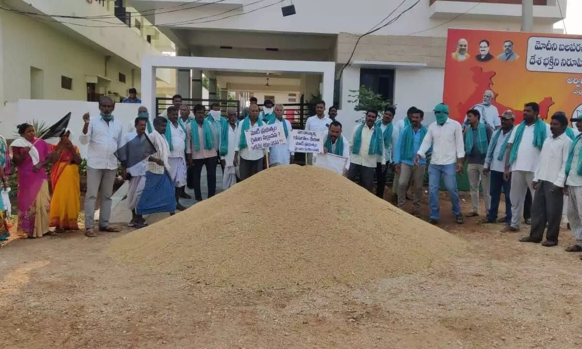 Farmers dumping paddy before MP Arvind’s house demanding him to buy the same from them, in Nizamabad on Tuesday