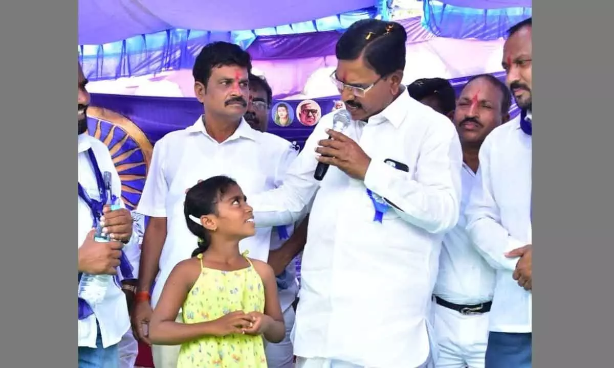 Agriculture Minister Singireddy Niranjan Reddy speaking to the orphan girl Ashwini at Upparipally village in Ghanapur mandal in Wanaparthy district