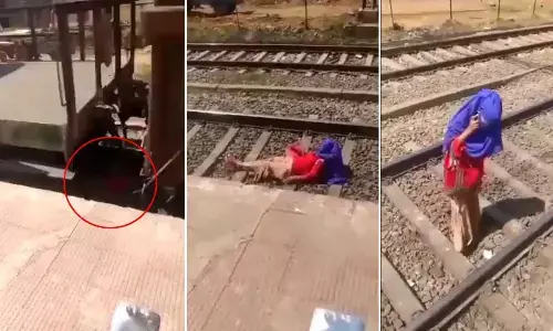 A Woman Talking On Phone As Train Passes Over Her