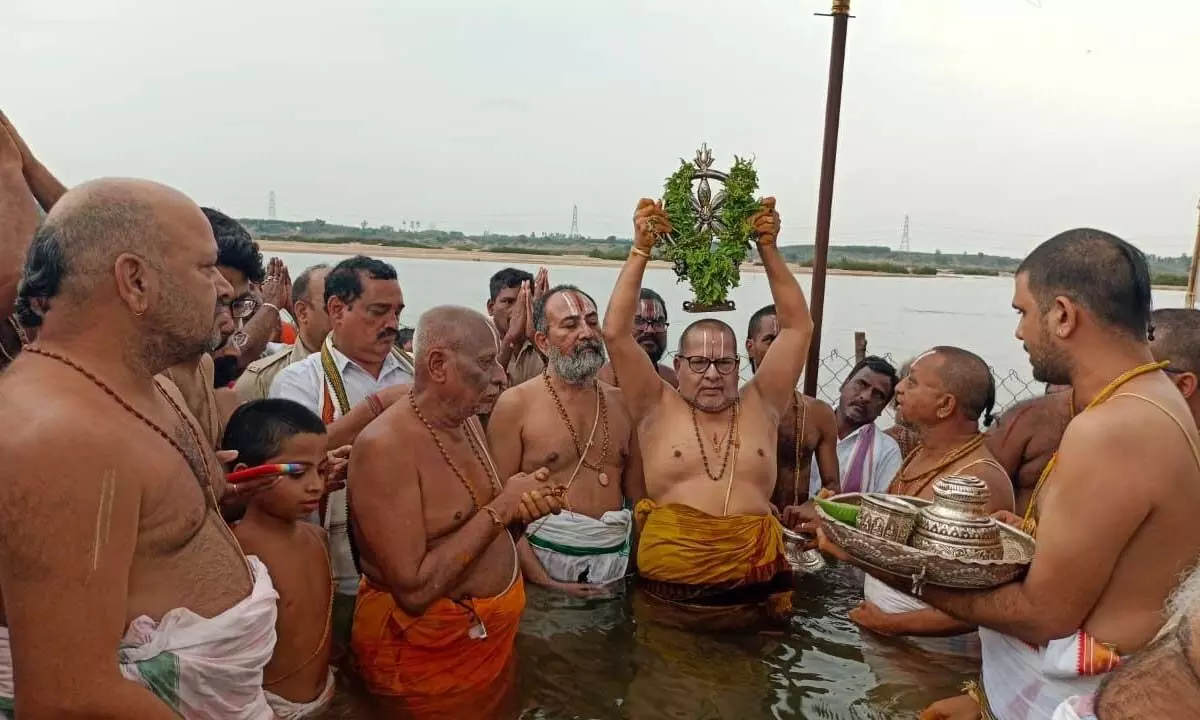 The priest performing Chakrasnanam programme at the bank of river Godavari on Saturday